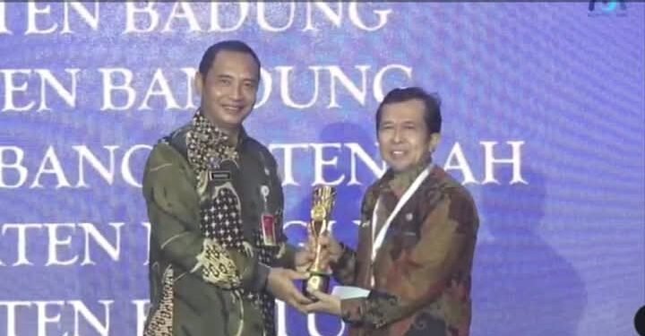 Bupati Dharmasraya melalui Kepala Badan Perencanaan Pembangunan, Riset dan Inovasi Daerah, (Bapperida), Paryanto, terima penghargaan di Surabaya, (5/12/24)